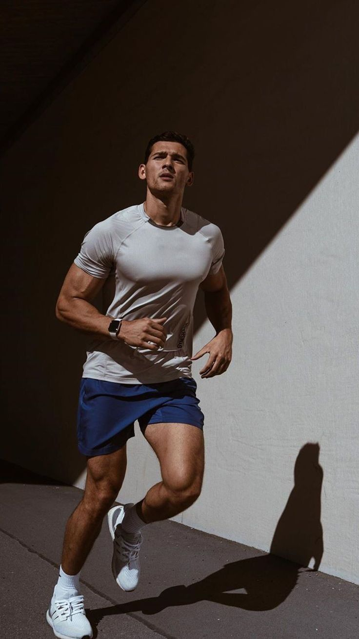 A man standing in sunlight beside a wall